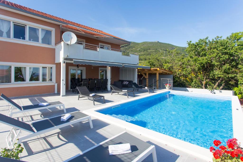 a swimming pool in the backyard of a house at Villa Ivano with sea&mountain view in Kastel Stari