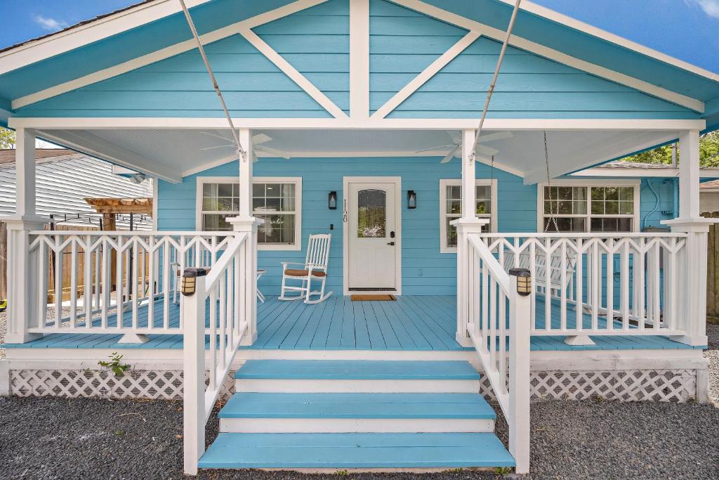 una casa blu con portico bianco e scale di Blue Bungalow In Houston Heights! Walkable to Popular Bars a Houston