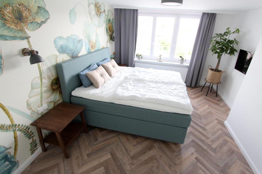 1 dormitorio con 1 cama con sábanas blancas y almohadas rosas en PEMATRA Haus Waterkant - FeWo Koje, en Travemünde
