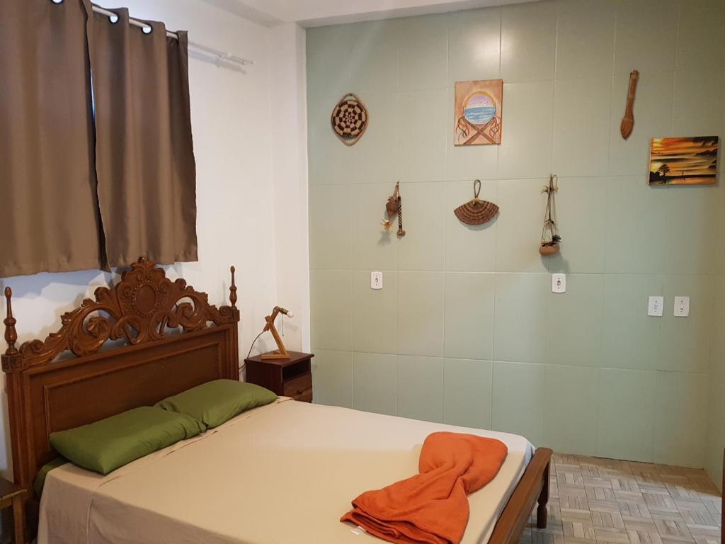 a bedroom with a bed with an orange towel on it at Casa Tribus Itamambuca in Ubatuba