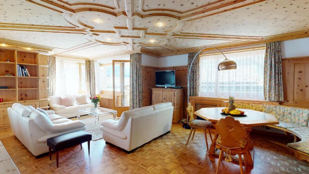a living room with a couch and chairs and a table at Paravicini 1 in St. Moritz