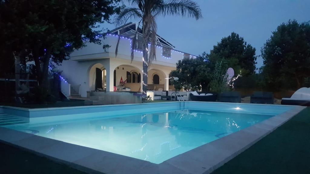 a swimming pool in front of a house at Villa More in Monteroni di Lecce