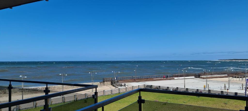 a view of a beach with the ocean and a pier at Apartament 33 przy latarni in Darłowo