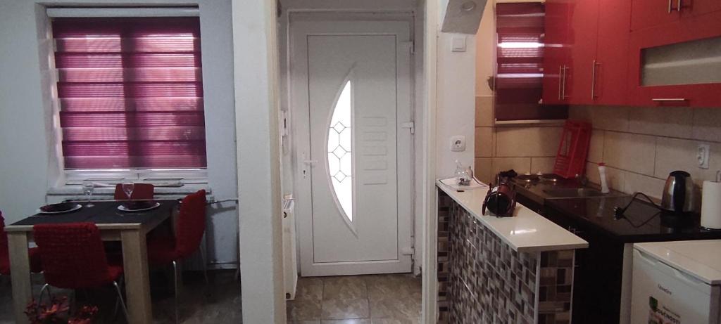 a kitchen with red cabinets and a white door at Lara in Doboj