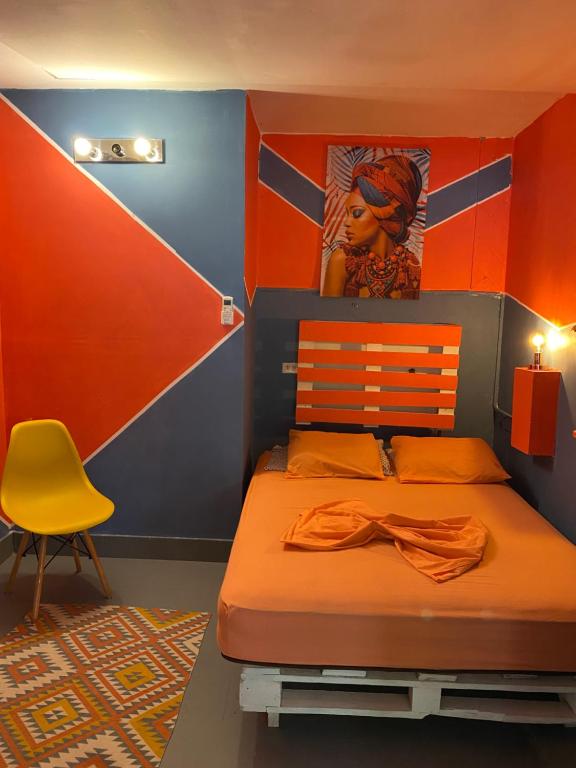 a bedroom with a bed and a yellow chair at Zebulo Hostel in Panama City
