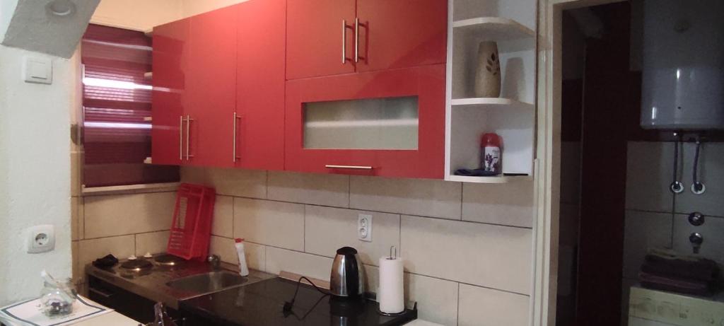 a kitchen with red cabinets and a sink at Lara in Doboj