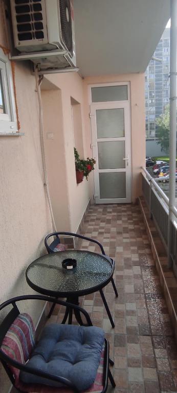 a patio with a table and chairs on a balcony at Lara in Doboj