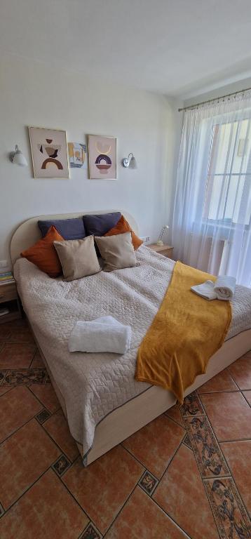 a bedroom with a large bed with pillows on it at Apartamenty Hexagon nr 9 in Grzybowo