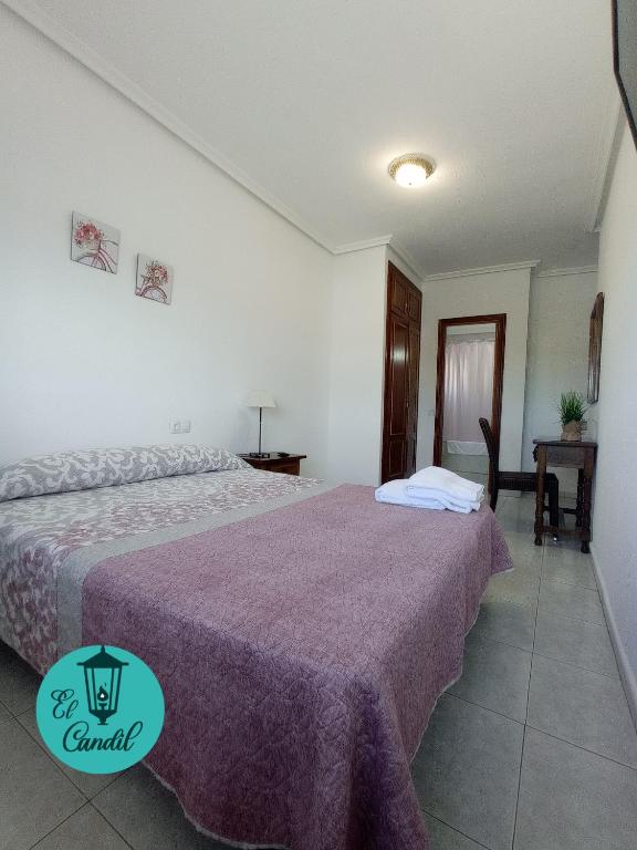 a hotel room with two beds and a table at EL CANDIL in Villacastín