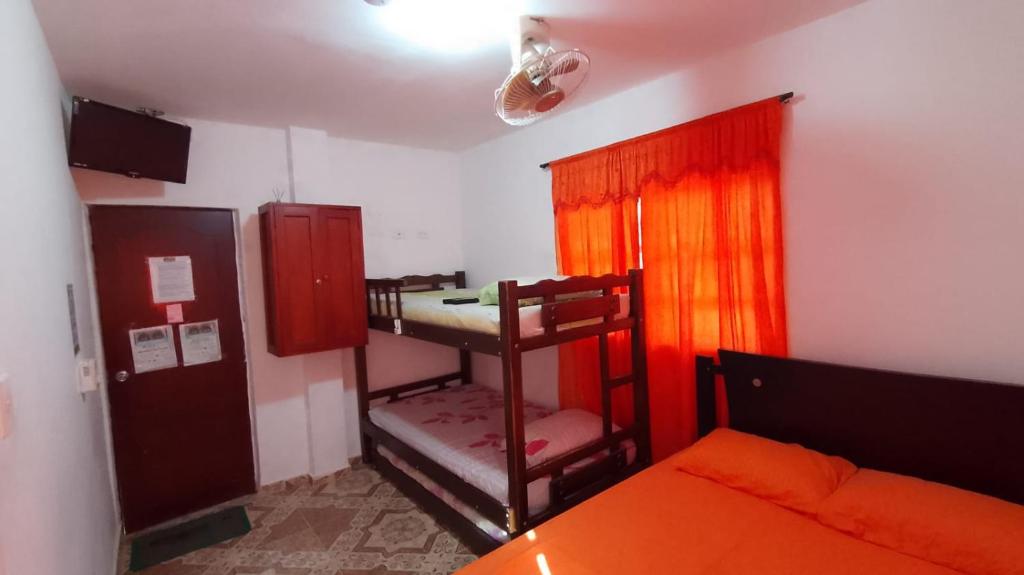 a small room with a bunk bed and a room with a bed and a bed at Hostal Casa Yhoanny in Taganga