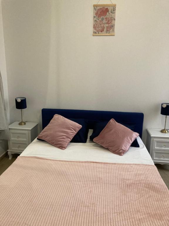 a bed with two pink pillows on top of it at Charmant F4 proche de la gare Saint Charles in Marseille