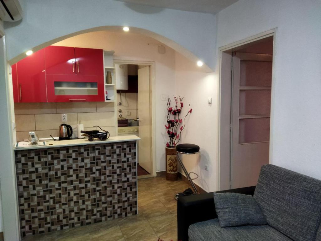 a kitchen with red cabinets and a couch in a room at Lara in Doboj