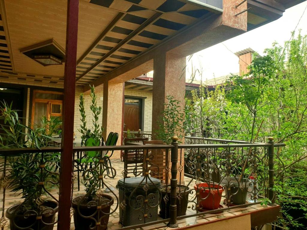 un porche con un montón de macetas. en HOTEL-129, en Samarkand