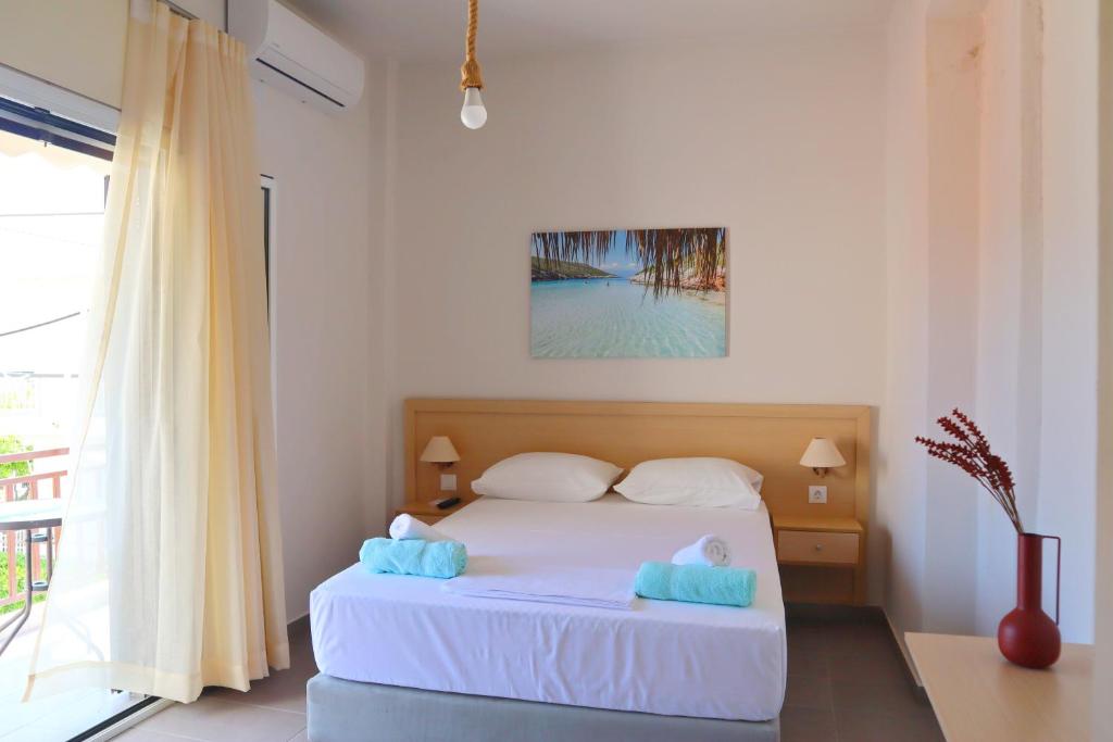 1 dormitorio con cama blanca y ventana en Το Κοράλι, en Amarinto