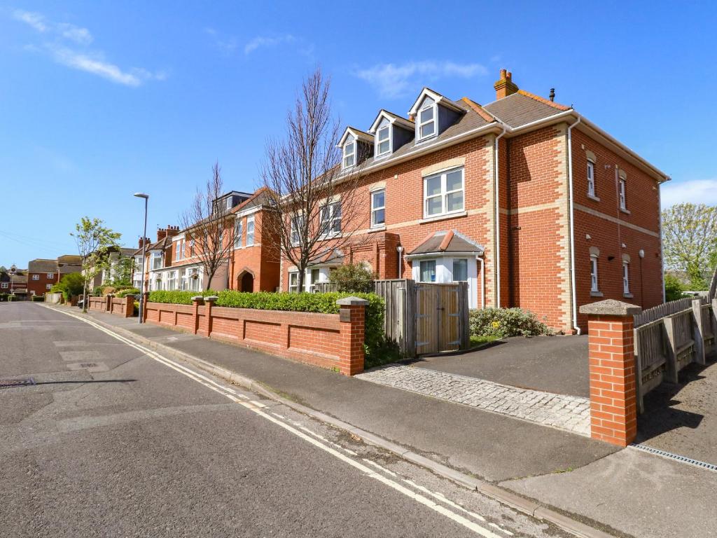 a brick house with a fence on the side of a street at Marina Reach in Weymouth