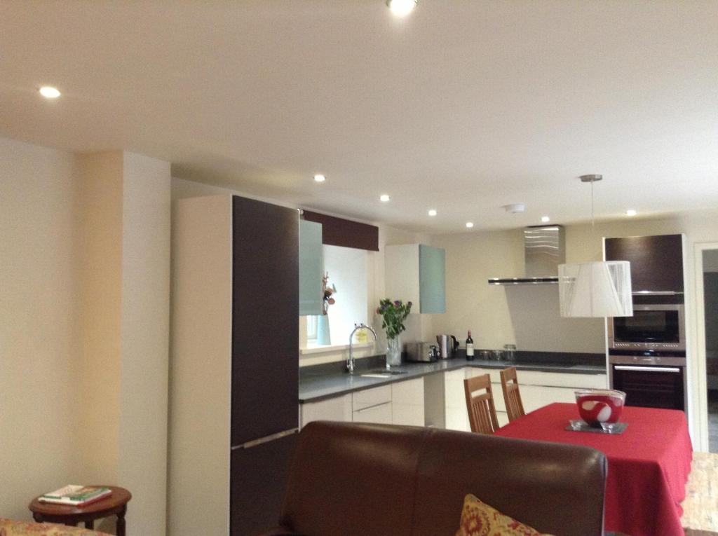 a kitchen and dining room with a red table and chairs at Best Beach 2025 "Little Haven" & The Hidden Gem in Haverfordwest