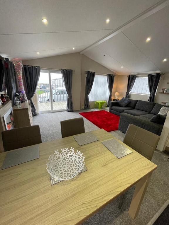 uma sala de estar com uma mesa e um sofá em Luxury Lodge em Heysham