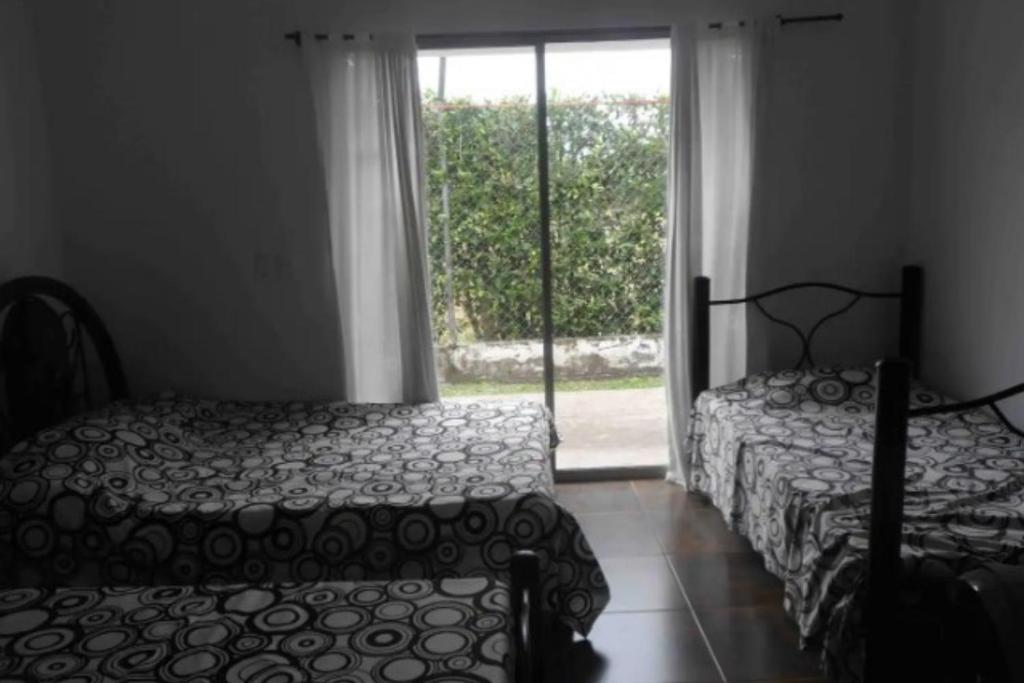 a bedroom with two beds and a window at Casa Vacacional para Familias en Villavicencio in Villavicencio