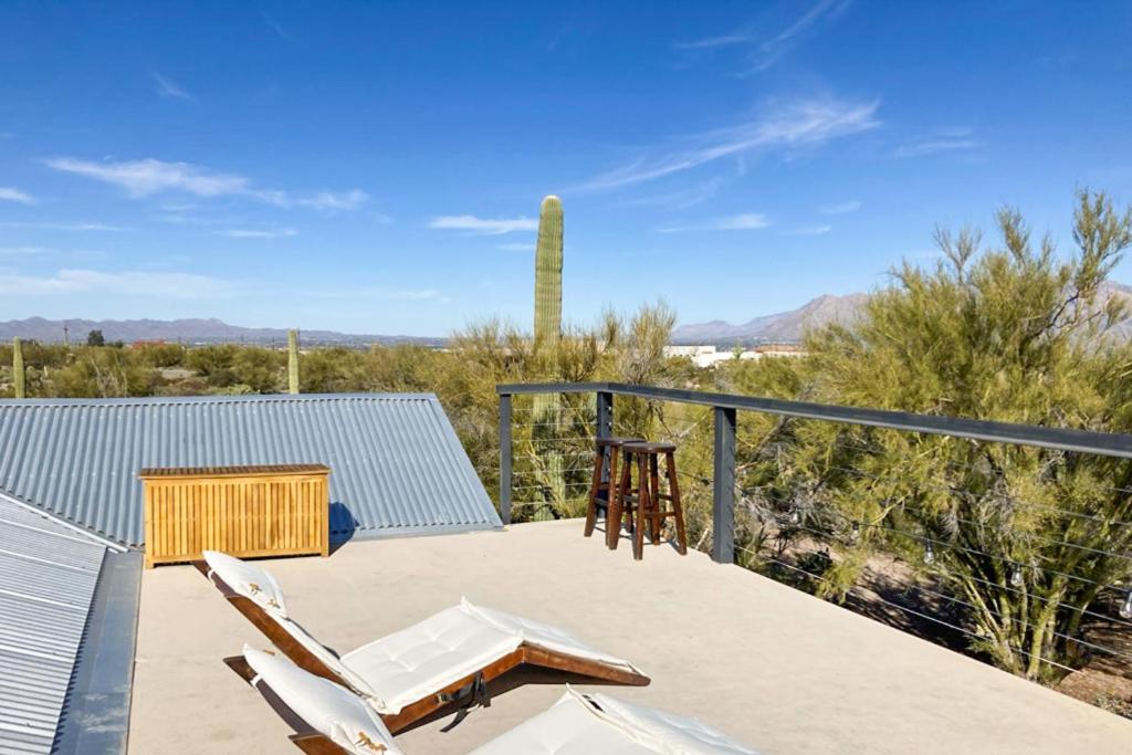 a deck with two chairs and a table and a cactus at Lazy C Ranch in Tucson