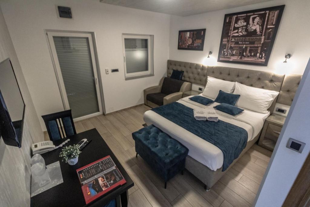 1 dormitorio con 1 cama grande y 1 sofá en Motel Atos Bungalovi, en Nova Topola