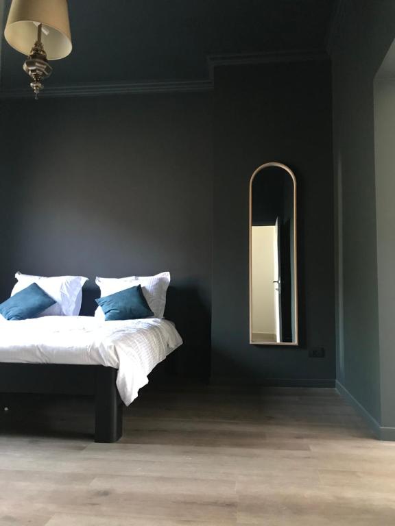 a bedroom with a bed and a mirror at Maison Georges in Turnhout