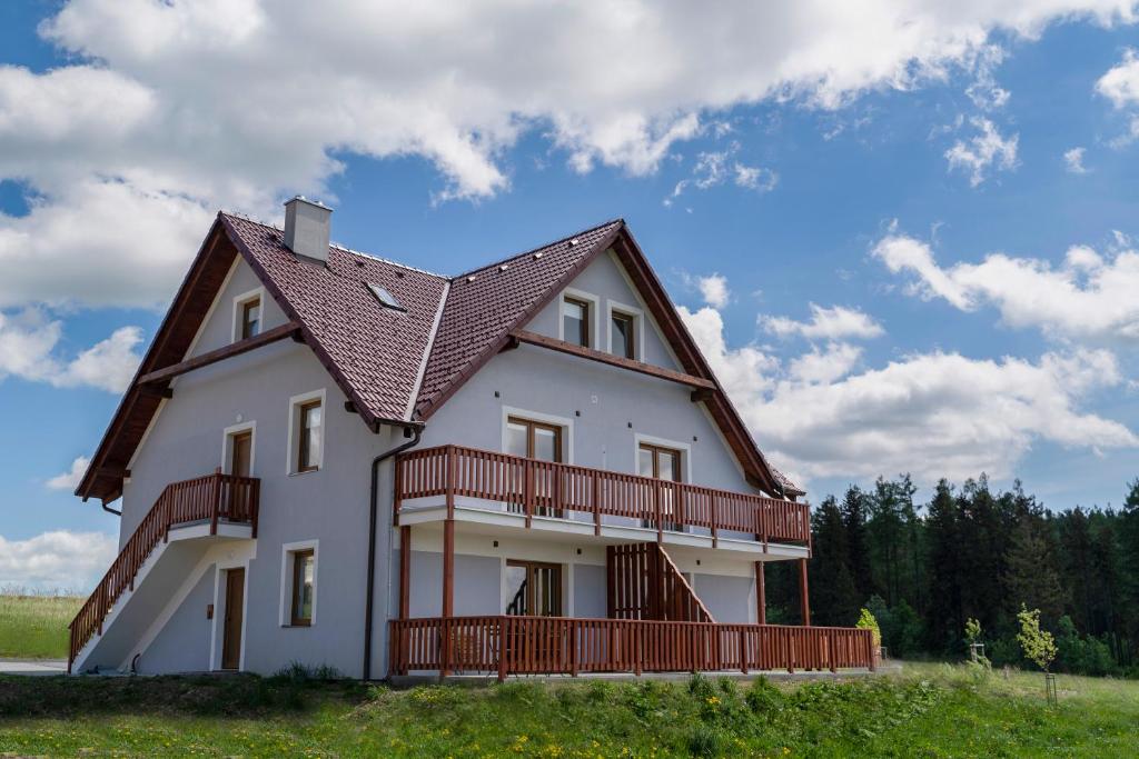 duży biały dom z brązowym dachem w obiekcie APARTMÁNY DRING w mieście Vaclavov u Bruntalu