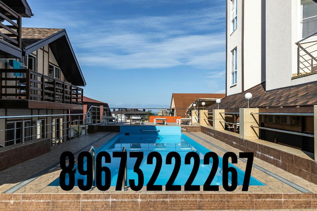 uitzicht op een zwembad tussen twee gebouwen bij Aranda Hotel in Adler