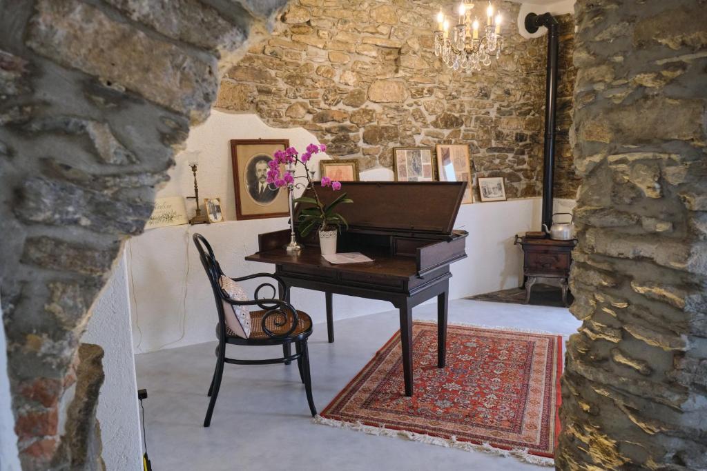 a piano in a room with a chair and a table at Agriturismo Le Merline in Arnasco