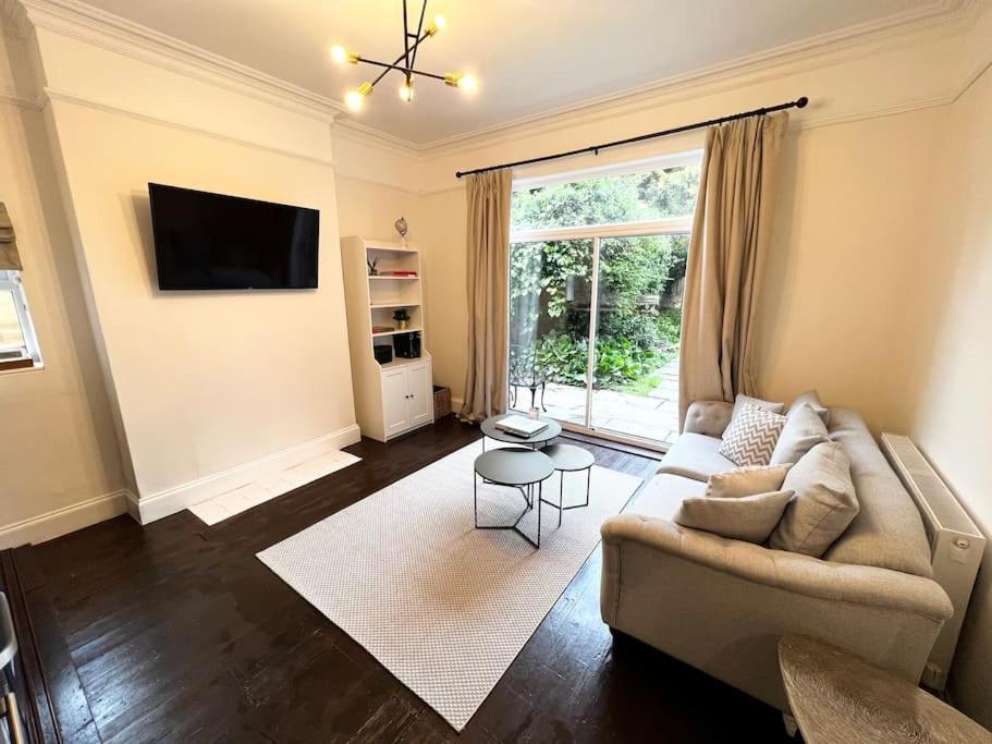 a living room with a couch and a large window at Entire apartment, 10mins from Cotswolds, Child friendly, Great Location & plenty of free parking nearby in Evesham