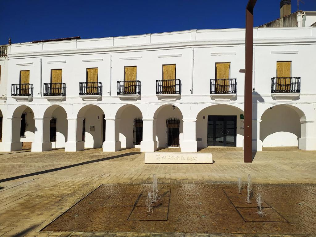 un grande edificio bianco con un cartello nel cortile di Casa Rural "Laplaza23" a Herrera del Duque