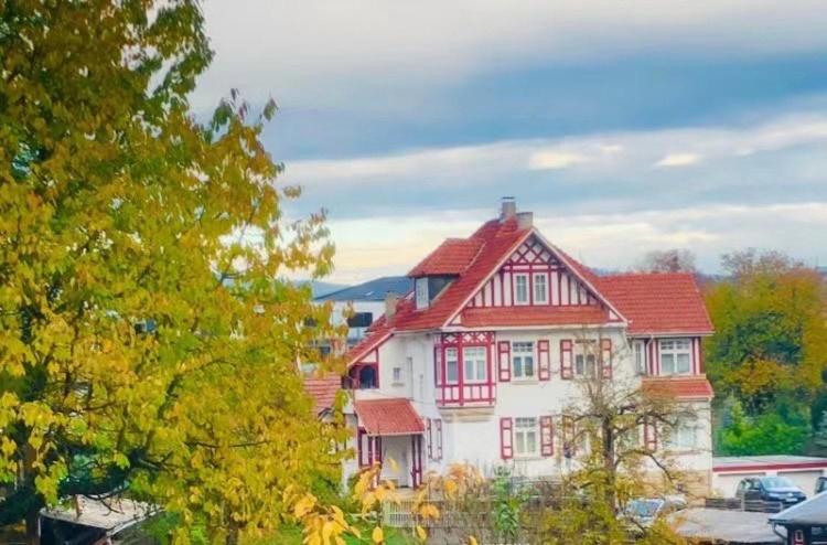 une grande maison blanche avec un toit rouge dans l'établissement Gästehaus Ambiente am Kurpark, à Bad Sooden-Allendorf