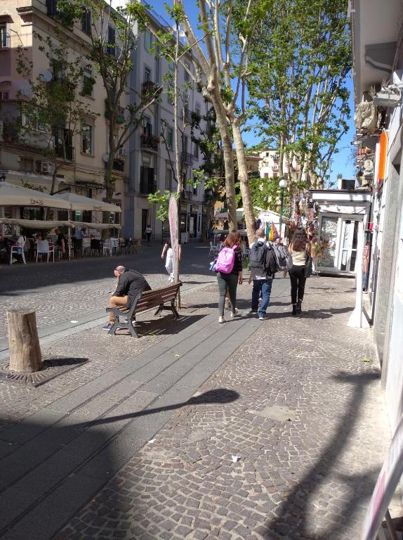 Un uomo seduto su una panchina in una strada di città di Neruda Chic House Vomero a Napoli