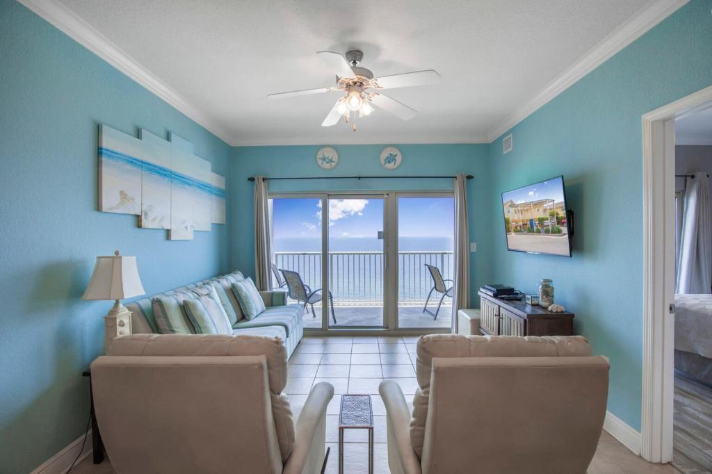 a living room with blue walls and a ceiling fan at Crystal Tower 1906 by Vacation Homes Collection in Gulf Shores