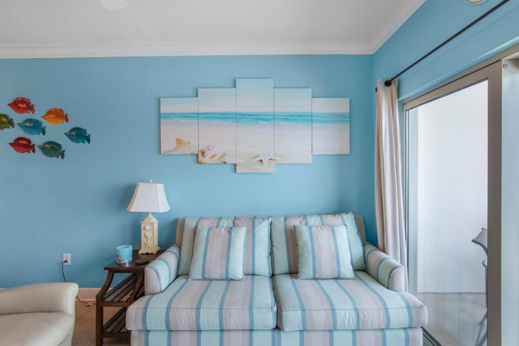 a living room with a couch and a blue wall at Crystal Tower 1906 by Vacation Homes Collection in Gulf Shores