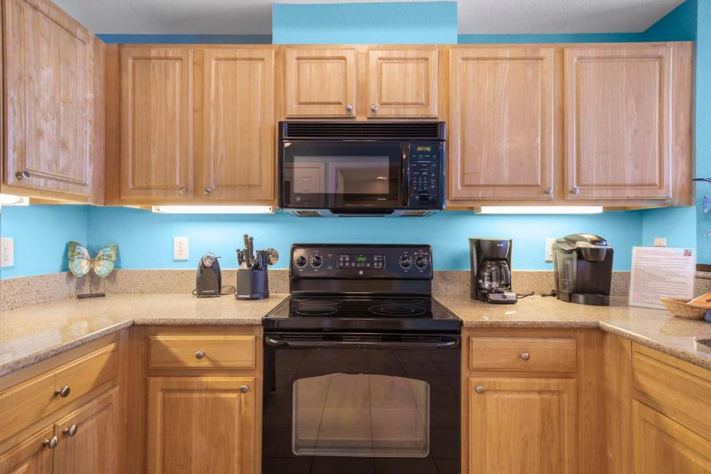 a kitchen with wooden cabinets and a black stove top oven at Crystal Tower 1906 by Vacation Homes Collection in Gulf Shores