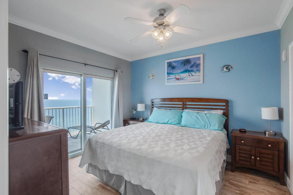 a bedroom with a bed and a balcony with the ocean at Crystal Tower 1906 by Vacation Homes Collection in Gulf Shores