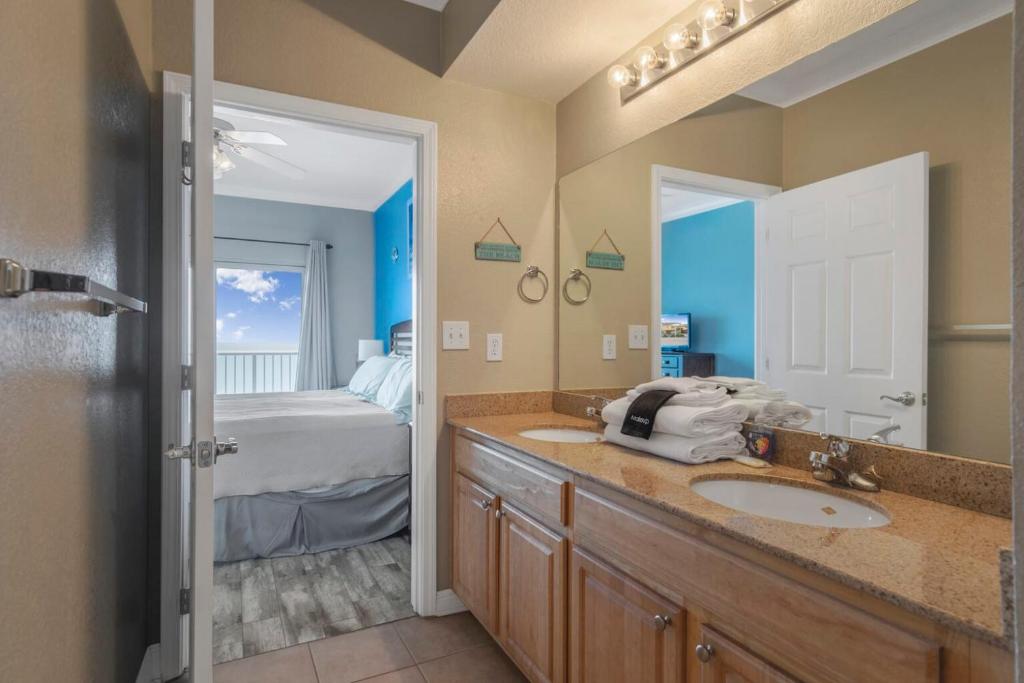 a bathroom with two sinks and a bedroom with a bed at Crystal Tower 1906 by Vacation Homes Collection in Gulf Shores