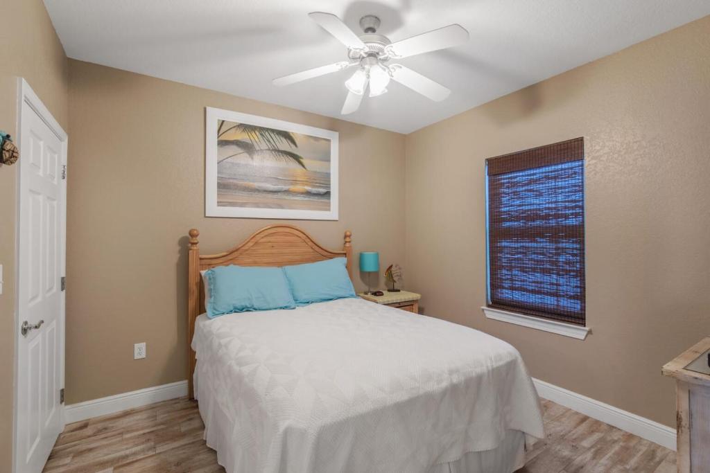 a bedroom with a bed with a ceiling fan and a window at Crystal Tower 1906 by Vacation Homes Collection in Gulf Shores