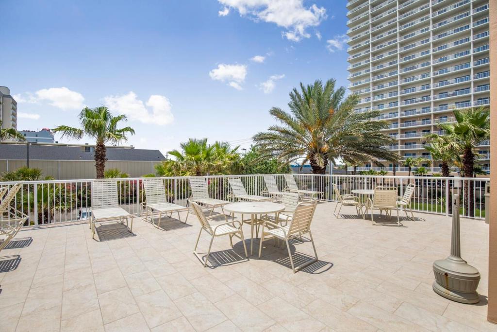 a patio with a table and chairs and a fence at Crystal Tower 1906 by Vacation Homes Collection in Gulf Shores