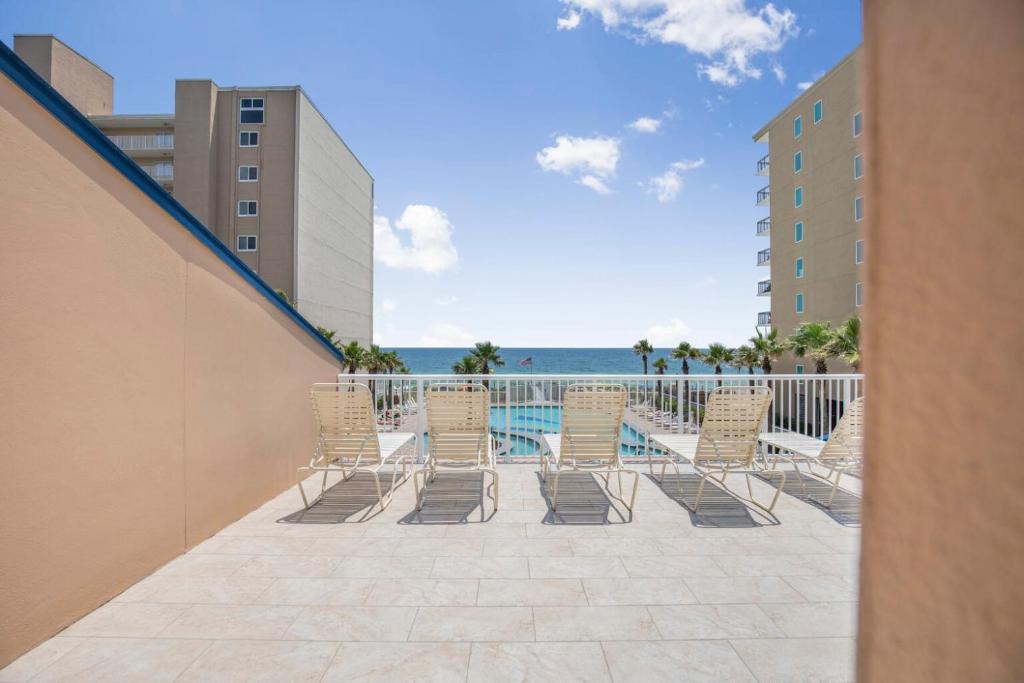 a row of chairs on a balcony with the ocean at Crystal Tower 1906 by Vacation Homes Collection in Gulf Shores