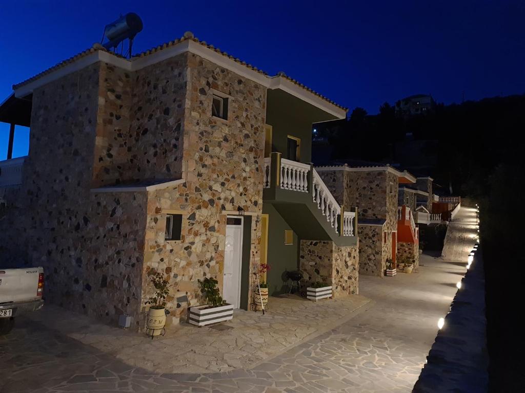 a stone house with a white door and stairs at Edem Studios in Syvota