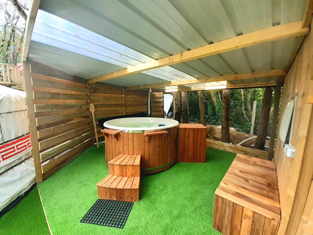un sauna avec un bain à remous et deux bancs dans l'établissement Ravissant yourte traditionnelle, à Quimper
