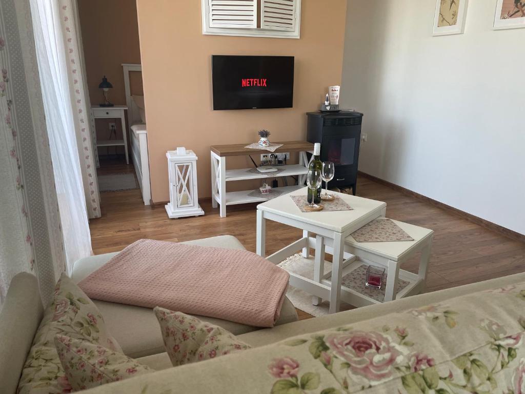 ein Wohnzimmer mit einem Sofa und einem TV in der Unterkunft Apartmán SIESTA 2 in Podhájska