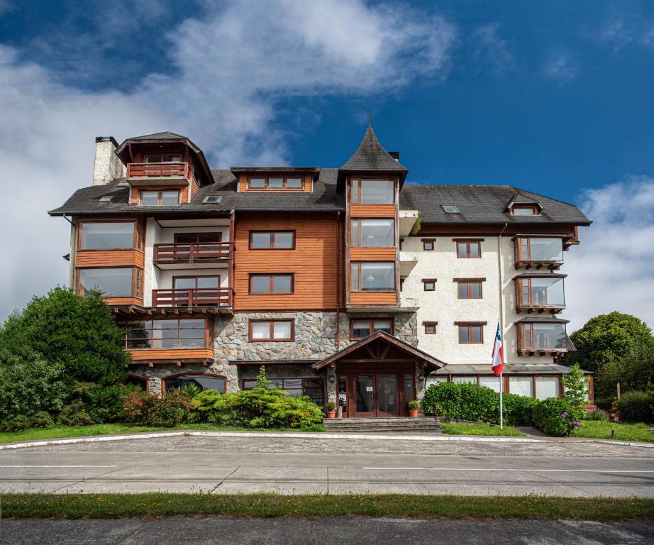 a large apartment building with a gambrel at Hotel Puelche in Puerto Varas