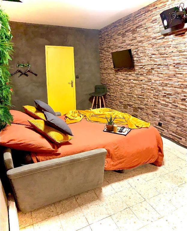 - un lit avec une couette en orange dans l'établissement Chambre Coté Terre & Coté Mer, à Cuxac-dʼAude
