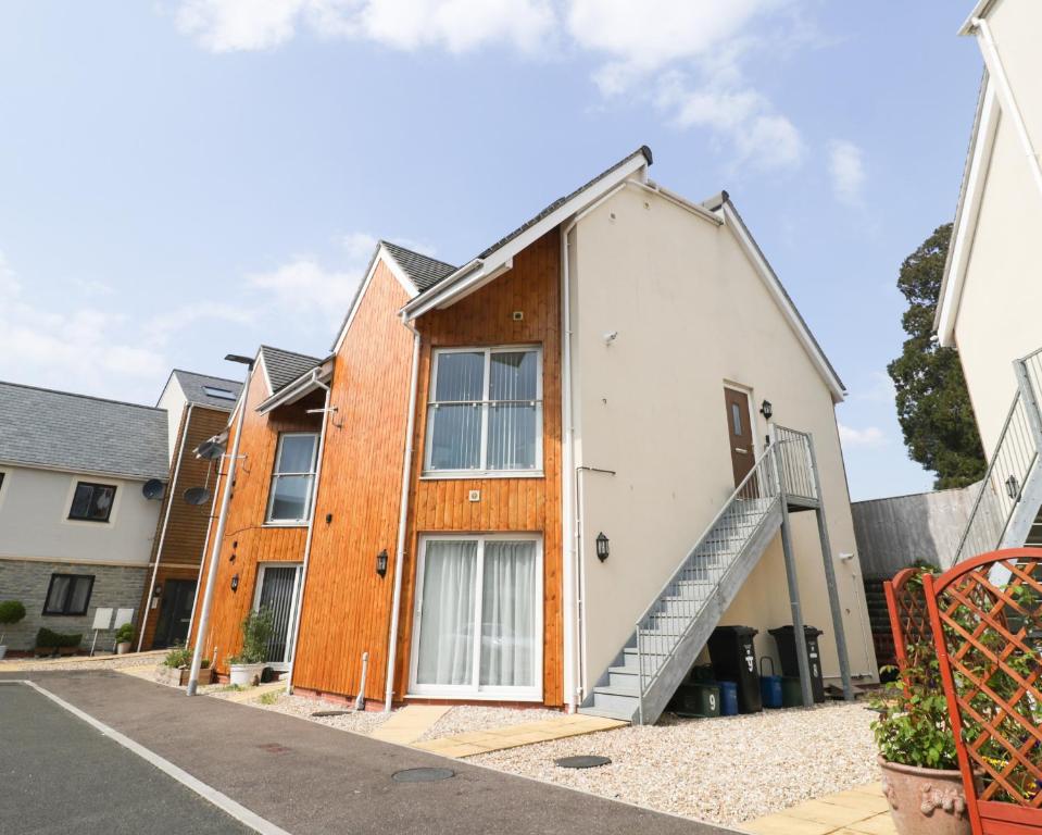 una casa con una puerta de madera en una calle en 9 Mitchell Gardens en Axminster