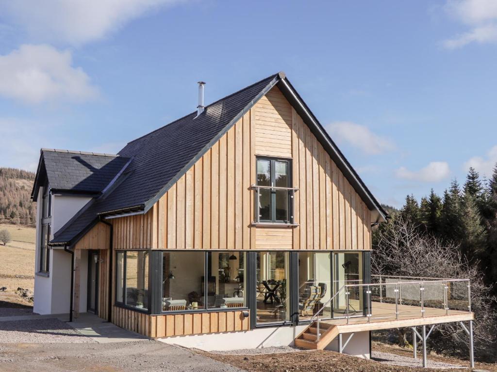 une maison avec de nombreuses fenêtres et une terrasse dans l'établissement Westertown, à Strathdon