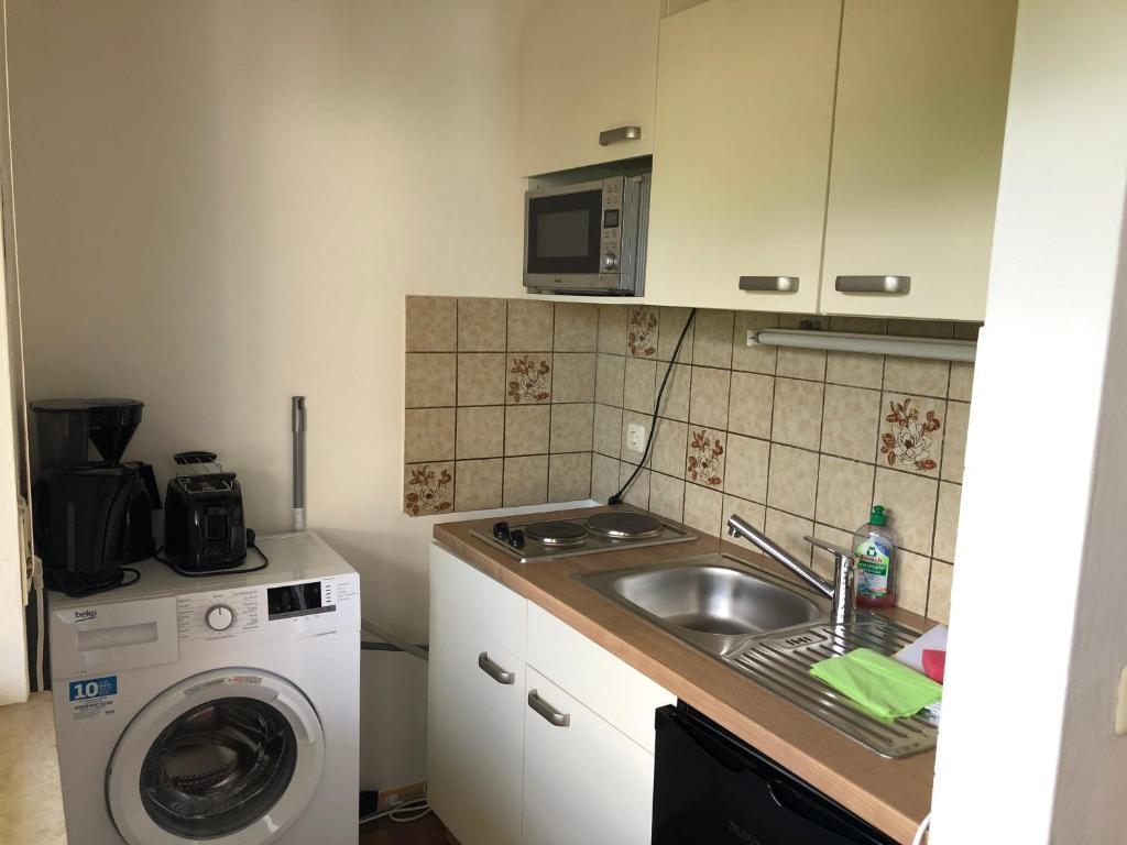 a kitchen with a sink and a washing machine at Apartment Colonia in Garmisch-Partenkirchen