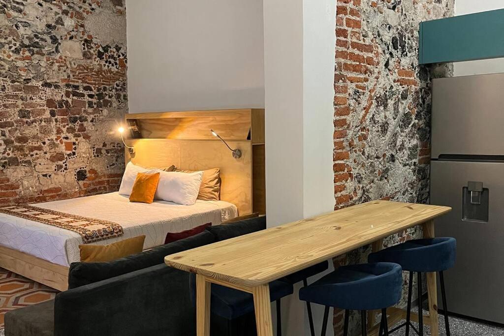 a room with a bed and a table and a couch at 107 SUITES DONCELES CENTRO HISTÓRICO CDMX in Mexico City
