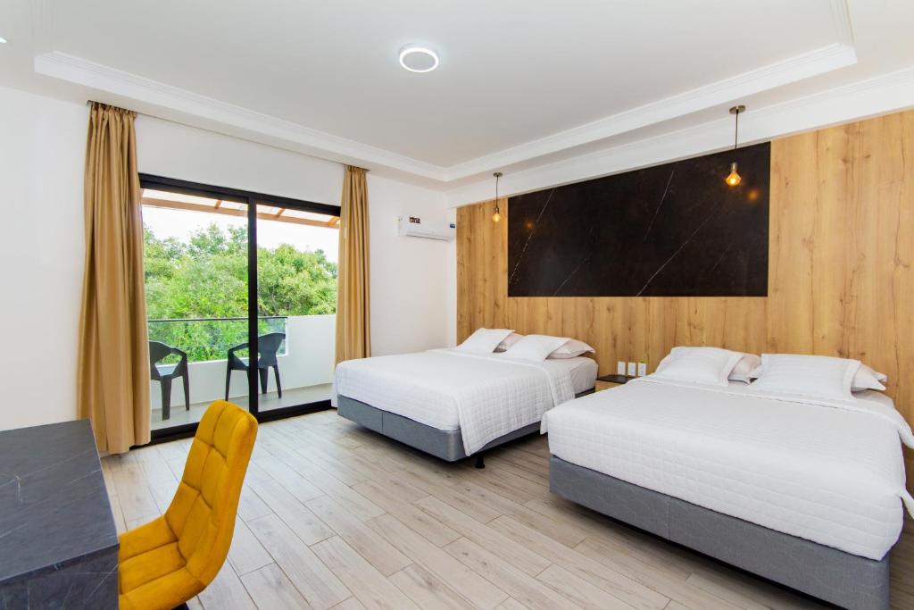 two beds in a room with a balcony at Grand Hotel Leon Marino Galapagos in Puerto Ayora